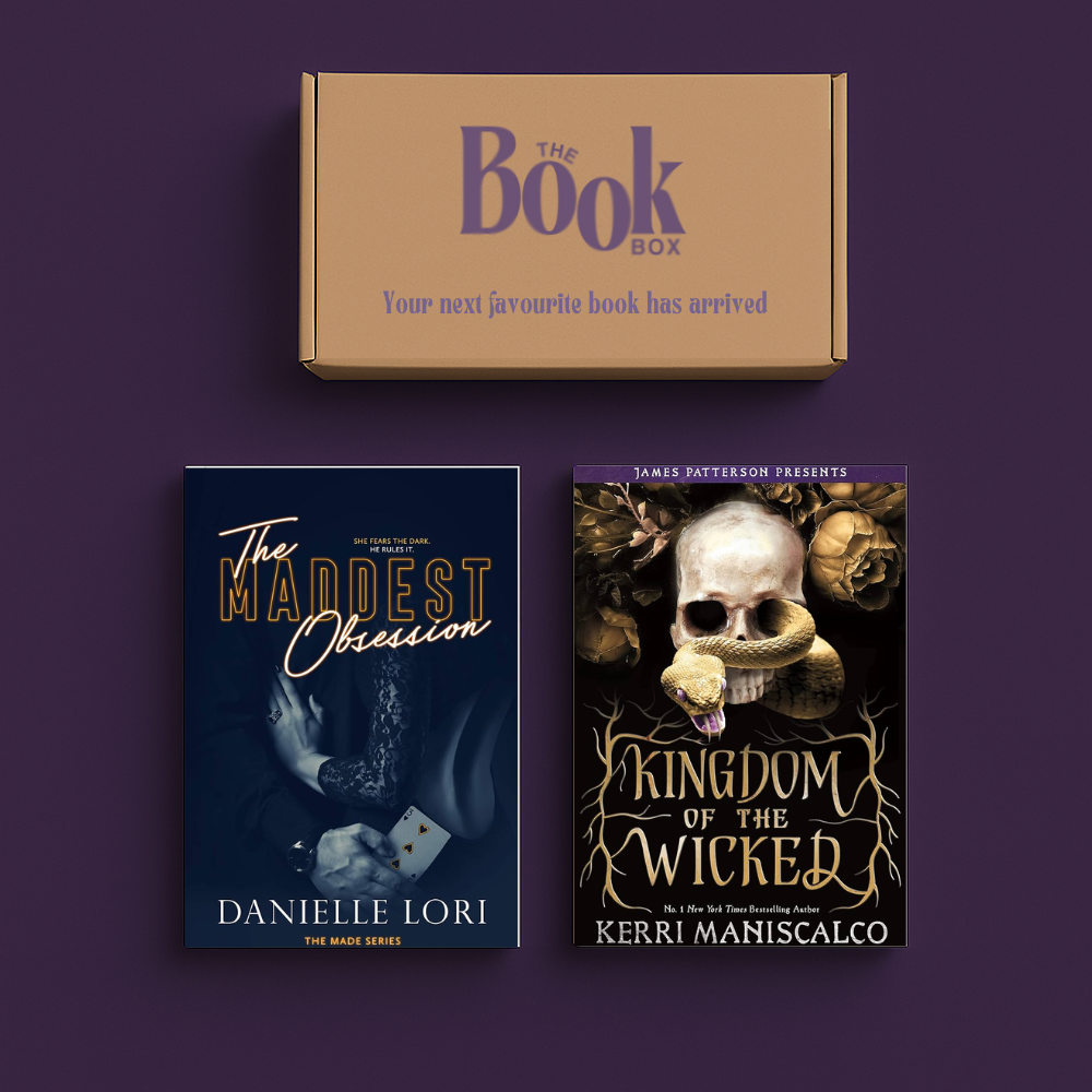 Moody dark romance book box setup with spicy novel on flatlay background.